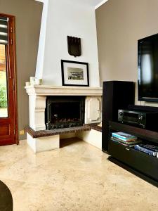 een woonkamer met open haard en tv bij Private Rooms & Bath in Tonneins