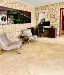 een woonkamer met stoelen en een stenen muur bij Private Rooms & Bath in Tonneins +11 foto's