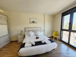 a bedroom with a large white bed with towels on it at Guest House Ainsa Pirineos in Aínsa
