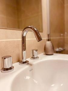 a sink with a faucet in a bathroom at Tucuman Suite Bariloche in San Carlos de Bariloche