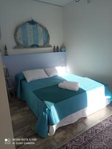 a bedroom with a bed with a blue comforter at Casa Batty in Sori