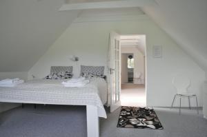 een witte slaapkamer met een bed en een hal bij Fredensborg Guesthouse in Fredensborg