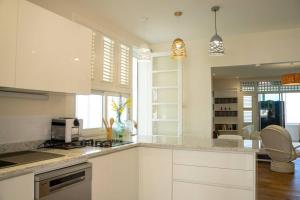 a kitchen with white cabinets and a counter top at Domaine des Tourterelles in Capesterre