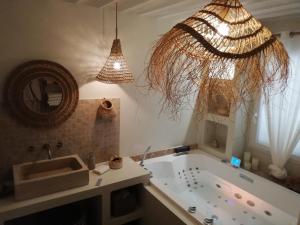 a bathroom with a tub and a sink and a mirror at La Petite perle, balnéo en supplément, le Clos des Perles in Tourtour +34 photos