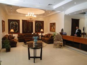 a man is standing in a lobby with a waiting room at Shanasheel Palace Hotel in Baghdad