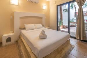 a hotel room with a bed and a dresser at Hotel Boutique Pachamama in Mahahual
