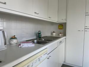 a kitchen with white cabinets and a sink at Ascona: San Materno-Mary in Ascona
