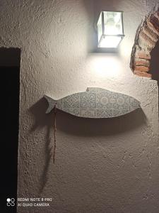 a fish decoration on a wall with a light at Petite Batty in Sori