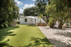 um quintal com uma casa branca com um relvado em Casa Terra Lumi em Fort Lauderdale
