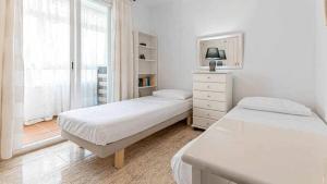 biała sypialnia z dwoma łóżkami i oknem w obiekcie 797 HOLIDAY RENTALS - Piso para 4 con amplia terraza al jardin y al mar w mieście Benalmádena +14 zdjęć