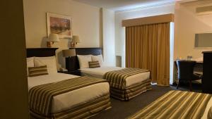 una camera d'albergo con due letti e una scrivania di Hotel Zafra a Torreón Altre 32 foto
