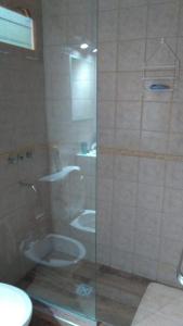 a bathroom with a glass shower with a toilet at Cabaña potrerillos La Tabaida in Potrerillos