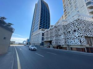 samochód jadący ulicą obok wysokich budynków w obiekcie Megafun Lux w mieście Baku