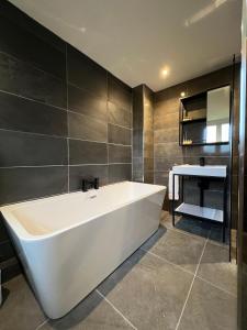 a bathroom with a white tub and a sink at Ty Gwyn Holiday Cottage - Llanbedr Dyffryn Clwyd - Ruthin in llanbedr-dyffryn-clwyd