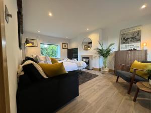 a bedroom with a bed and a living room at Ty Gwyn Holiday Cottage - Llanbedr Dyffryn Clwyd - Ruthin in llanbedr-dyffryn-clwyd