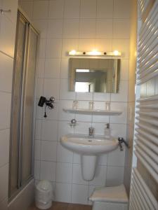 a bathroom with a sink and a mirror at FeWo ABDENA DORN200 in Dornum