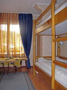 a bedroom with two bunk beds and a table at Vila Livadeto in Troyan