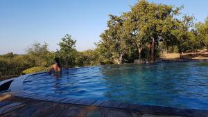 a person sitting in a pool of water at Game Lodge bordering Kruger with splash pool in Phalaborwa