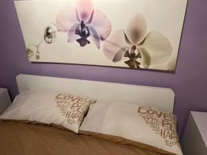 1 dormitorio con 1 cama con 2 flores en la pared en Whitehouse, en Capurso