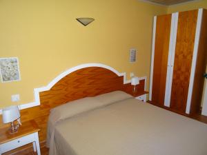 a bedroom with a bed with a wooden headboard at Precioso apartamento de dos hab. en Calan Bosch in Ciutadella