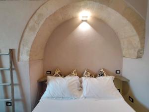 Un dormitorio con una cama blanca con un arco encima. en La Casa Di Gio', en Matera