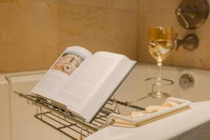 a book and a glass of wine sitting on a bath tub at Walk to Everything Downtown EAT - SHOP - PLAY in St Petersburg