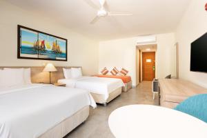 una camera d'albergo con due letti e una TV a schermo piatto di Royal Decameron Punta Sal - ALL INCLUSIVE a Canoas De Punta Sal