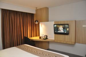 a hotel room with a tv on a wall at Sala View Hotel in Solo