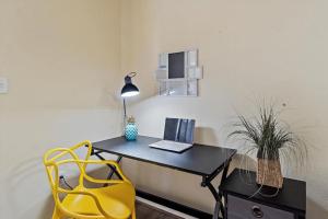 a desk with a laptop and a yellow chair at Sea Escape - Condo with Pool Hot Tub Plus Private Community Beach in St Petersburg