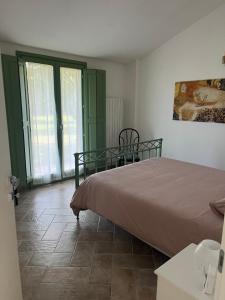 a bedroom with a bed and a table and windows at Casa Dora in Gubbio
