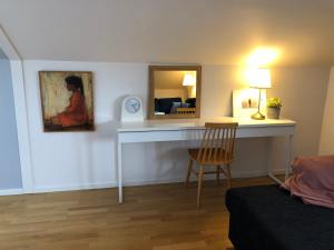 um quarto com uma secretária com um espelho e uma cadeira em Sofia Lägenhetshotell em Älmhult