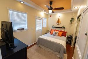 a bedroom with a bed and a flat screen tv at Wine-Dine-Sunshine Cozy Flat in The Heart of DTSP in St Petersburg