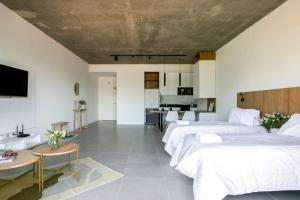 1 dormitorio con 2 camas, mesa y cocina en Departamento premium en Pilar 220 en La Lonja