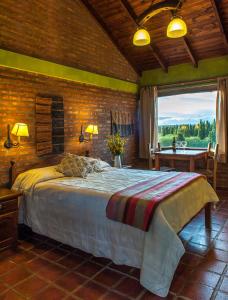 a bedroom with a bed and a large window at Posada Larsen in El Calafate +25 photos