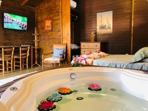 Shiva Guest House في فلوريانوبوليس: حوض استحمام في غرفة مع سرير