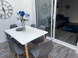 South NorwoodにあるModern 4 Bedroom House 10 mins from East Croydon with Garden and Free parkingの白いテーブルと椅子、青い花瓶 +26枚の写真