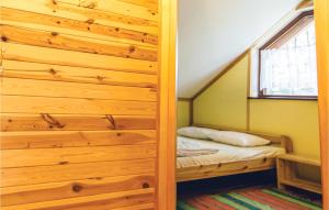 Habitación pequeña con cama y pared de madera. en Beautiful Home In Stawiguda, en Stawiguda