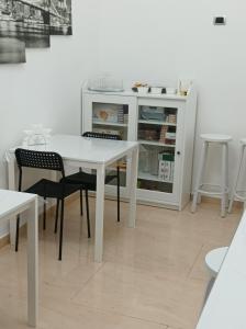 uma mesa branca e cadeiras ao lado de um frigorífico em B&B Nancy em Nápoles
