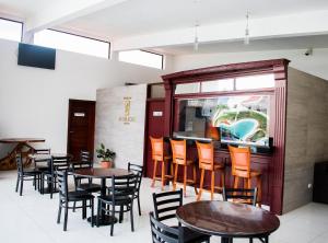 restauracja ze stołami i krzesłami oraz oknem w obiekcie Hotel Agualcas w mieście Managua
