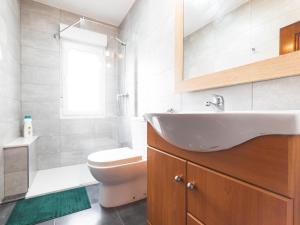 uma casa de banho com um lavatório e um WC em Apartamento cerra playa em Gijón