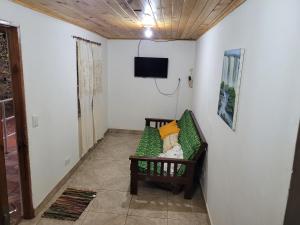 um quarto com um sofá e uma televisão na parede em Doña Isabel em Porto Iguaçu