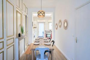una sala da pranzo con un lungo tavolo e sedie blu di Locations Tourcoing - Le Renaix a Tourcoing
