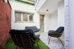 2 chaises et une table en face d'un bâtiment dans l'établissement Locations Tourcoing - Le Renaix, à Tourcoing