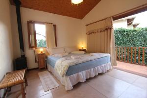 - une chambre avec un lit et un balcon dans l'établissement Pousada Asa do Vento, à São Luiz do Paraitinga