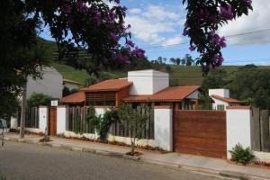 a house with a wooden fence at Pousada Asa do Vento in São Luiz do Paraitinga
