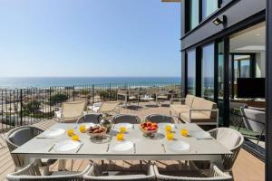 uma mesa branca com comida numa varanda com o oceano em American Colony - 300 sqm Sea View by HolyGuest em Tel Aviv