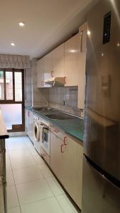 uma cozinha com um frigorífico de aço inoxidável e uma máquina de lavar louça em Apartamento Calle Turco 13 em Zaragoza