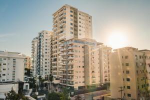een hoog appartementencomplex in een stad met gebouwen bij Fully Serviced Apartment at Regatta Living - 2C in Santo Domingo