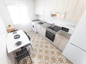 a small kitchen with a sink and a stove at Apartamento cerra playa in Gijón +11 photos