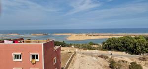 a building with a view of the ocean and a beach at Dar Assalam 1 in Oualidia